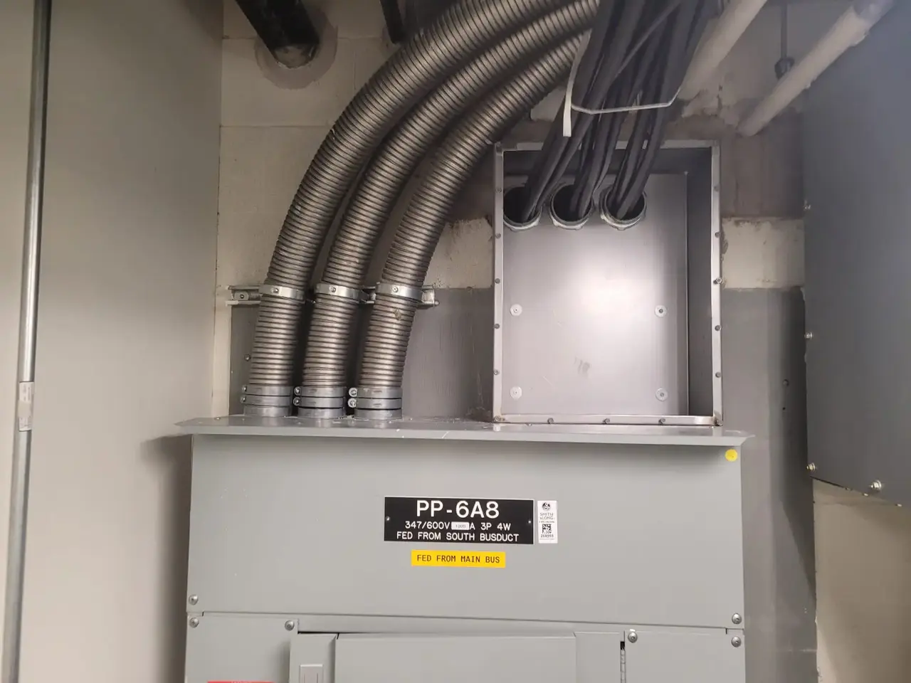 an electrical panel with conduits coming out of it