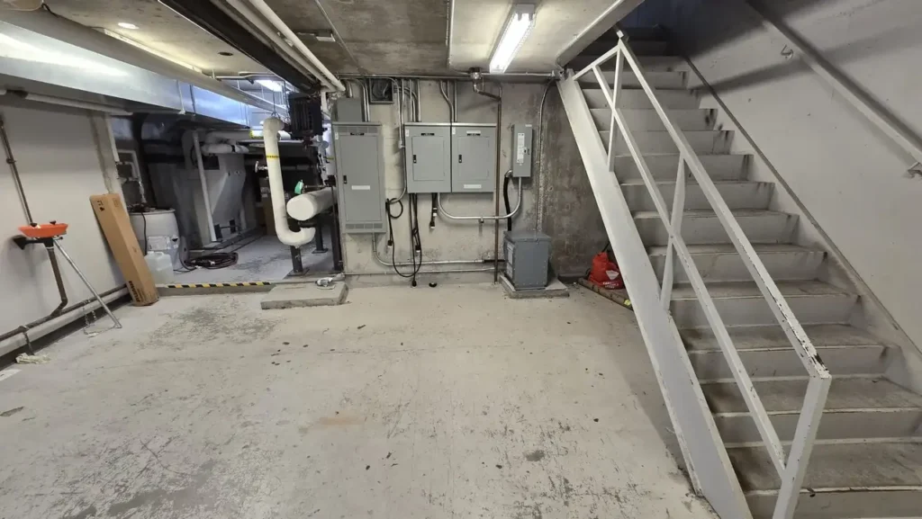 An unfinished basement with electrical panels