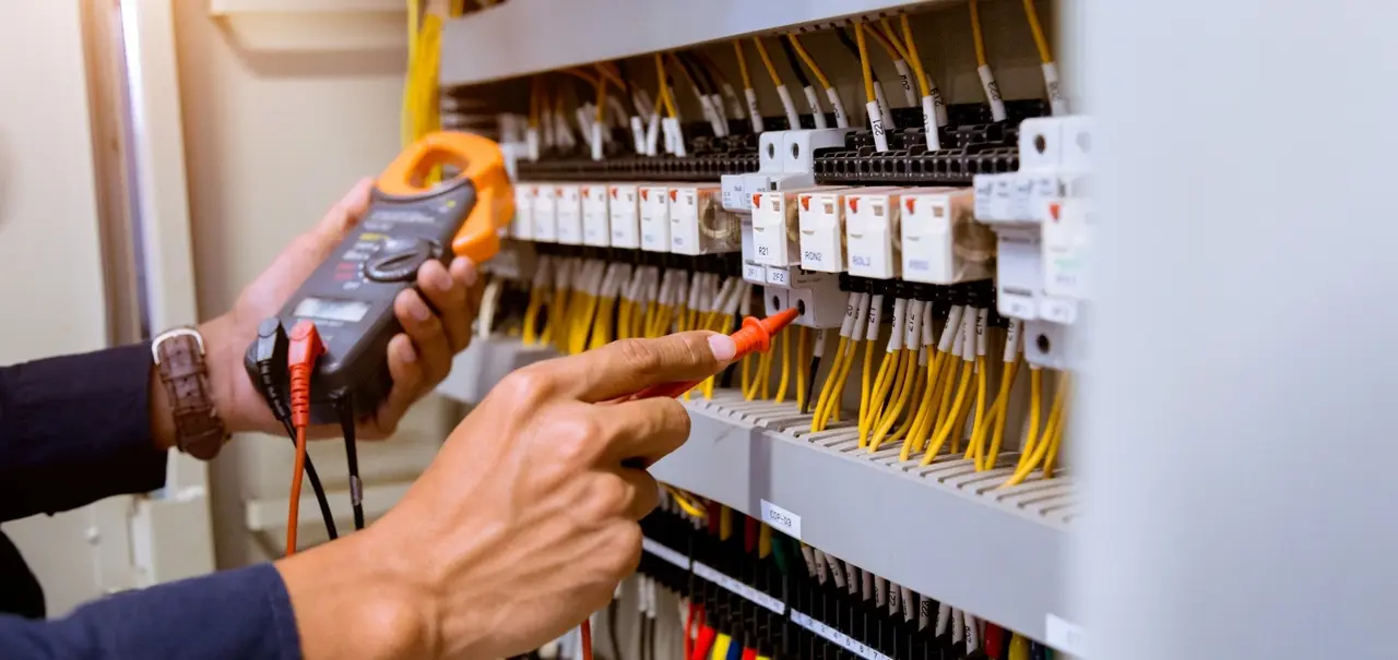 an electrician inspecting an electrical panel switches