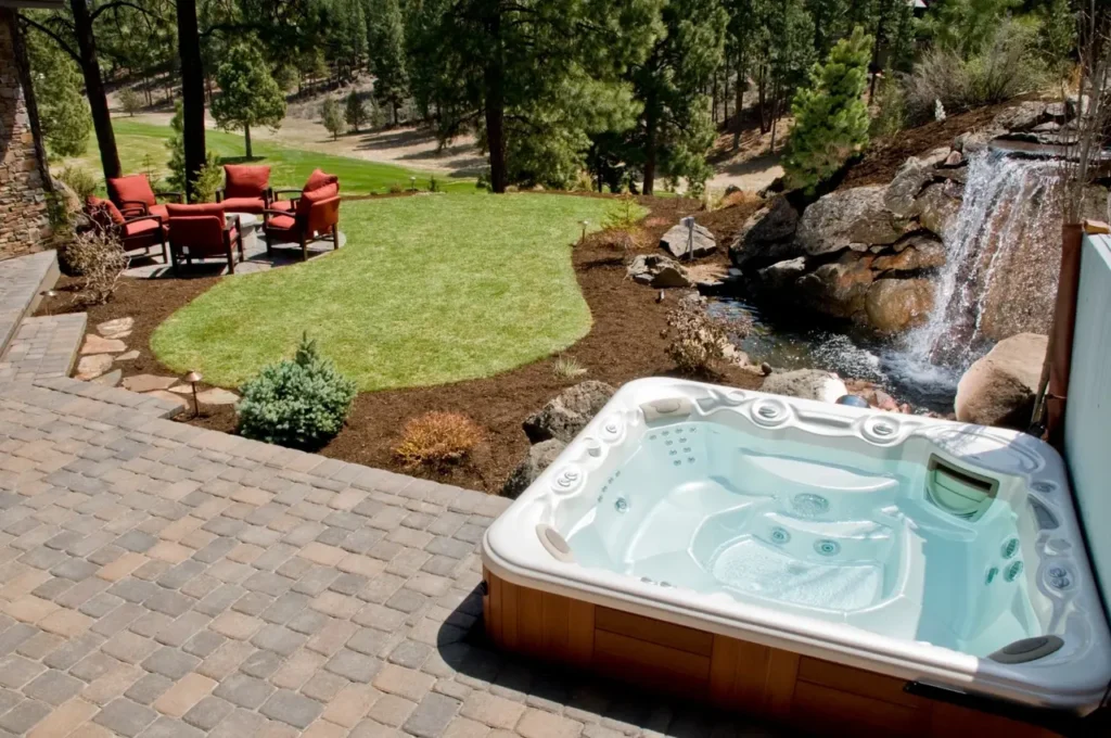 a hot tub in a well lanscaped rural backyard